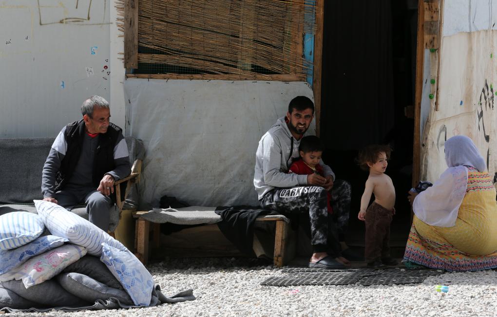 2018年4月12日，在希腊雅典以北约86公里处的里措纳难民营，一对夫妇照顾孩子。新华社发（马里奥斯·罗洛斯摄）