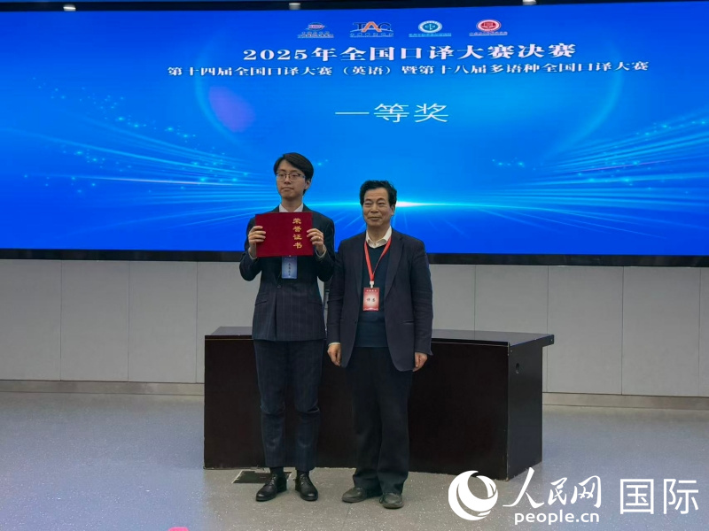 1. 全国俄语交替传译决赛评委会主席李俊升（右）为第一名获奖者刘睿劼（左）颁奖。人民网记者杨倩 摄